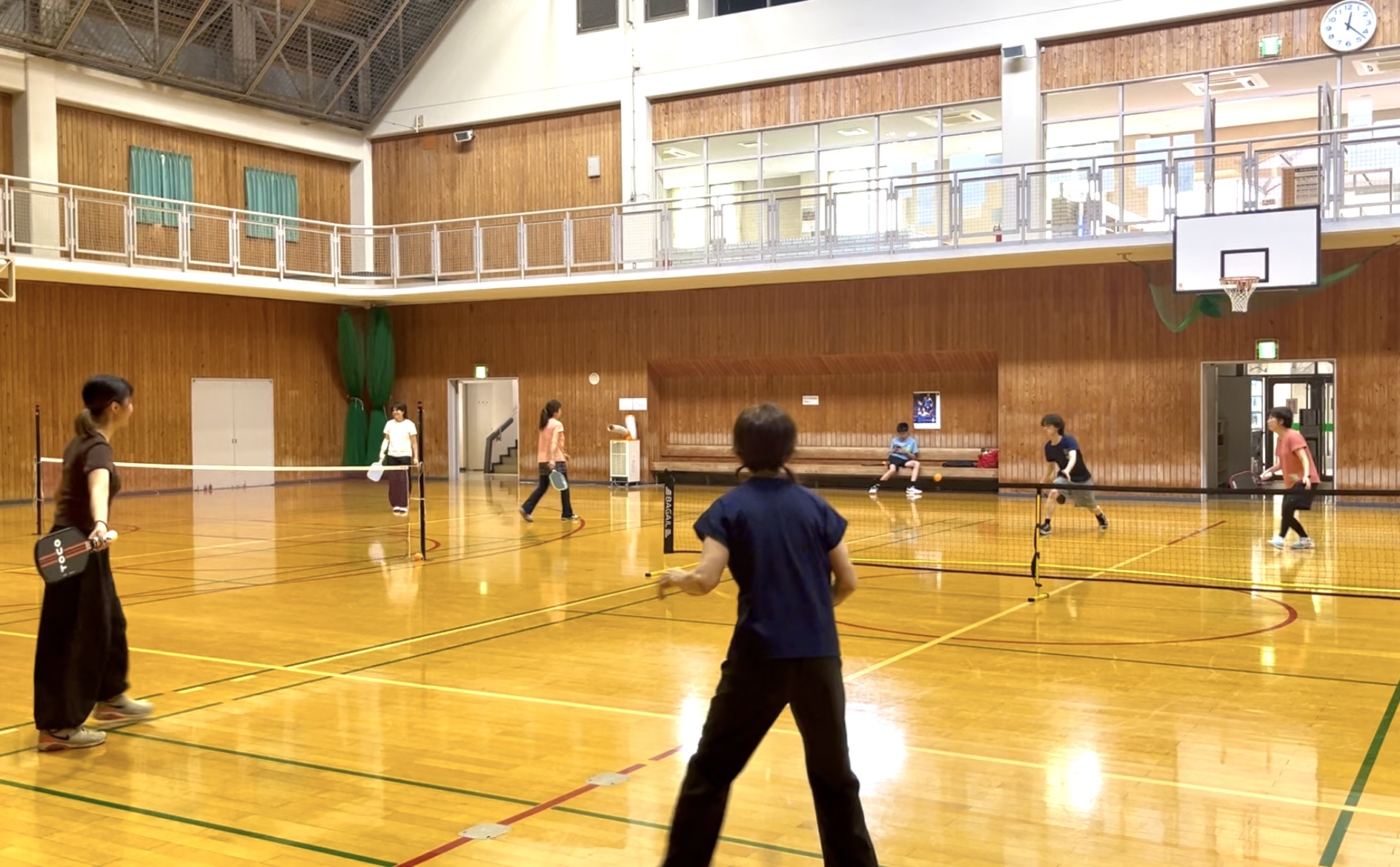 体育館でピックルボールのゲームをする参加者